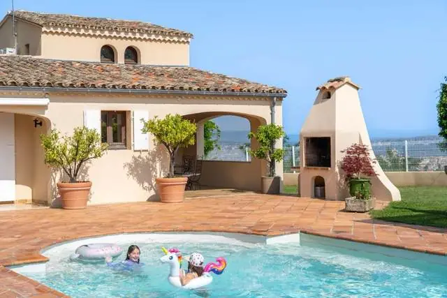 Piscine avec bouée licorne et cheminée extérieure