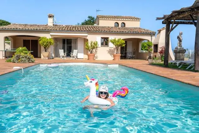 Enfant sur une bouée licorne dans la piscine