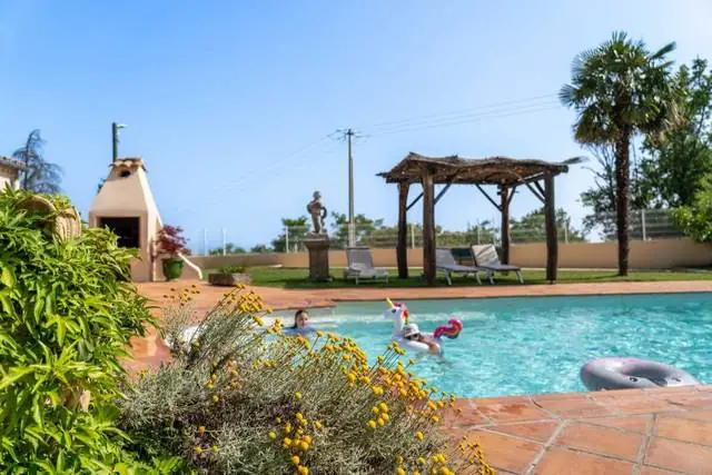 Piscine et jardin fleuri devant la villa