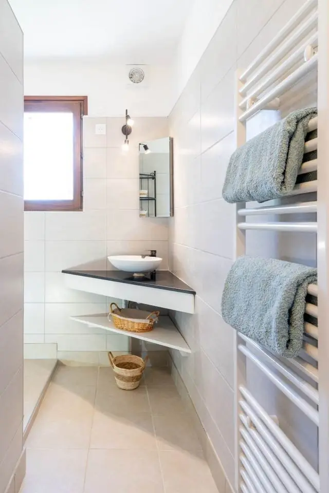 Salle de bain avec sèche-serviette et vasque