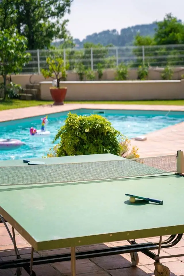 Piscine avec table de ping-pong au premier plan